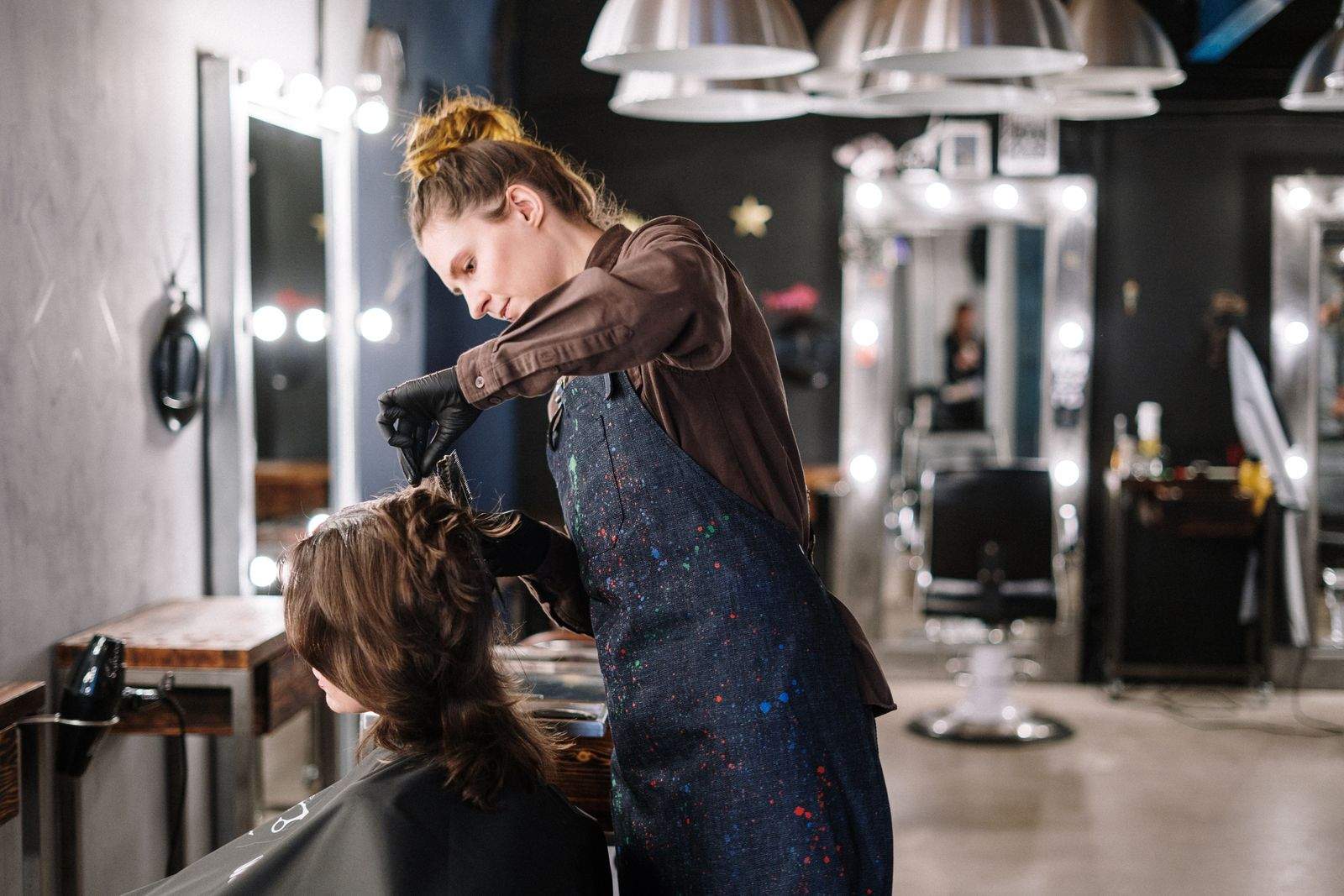 Profissional aplicando coloração em cabelo, salão de beleza