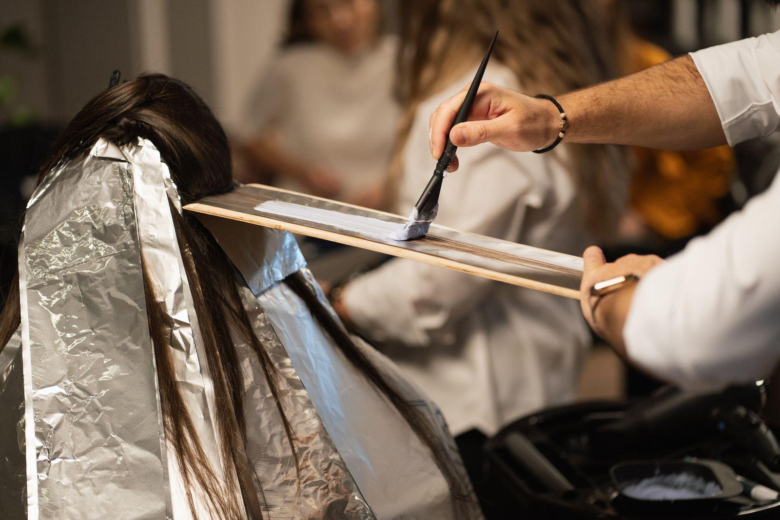 Aplicação de mechas com papel alumínio em salão de beleza